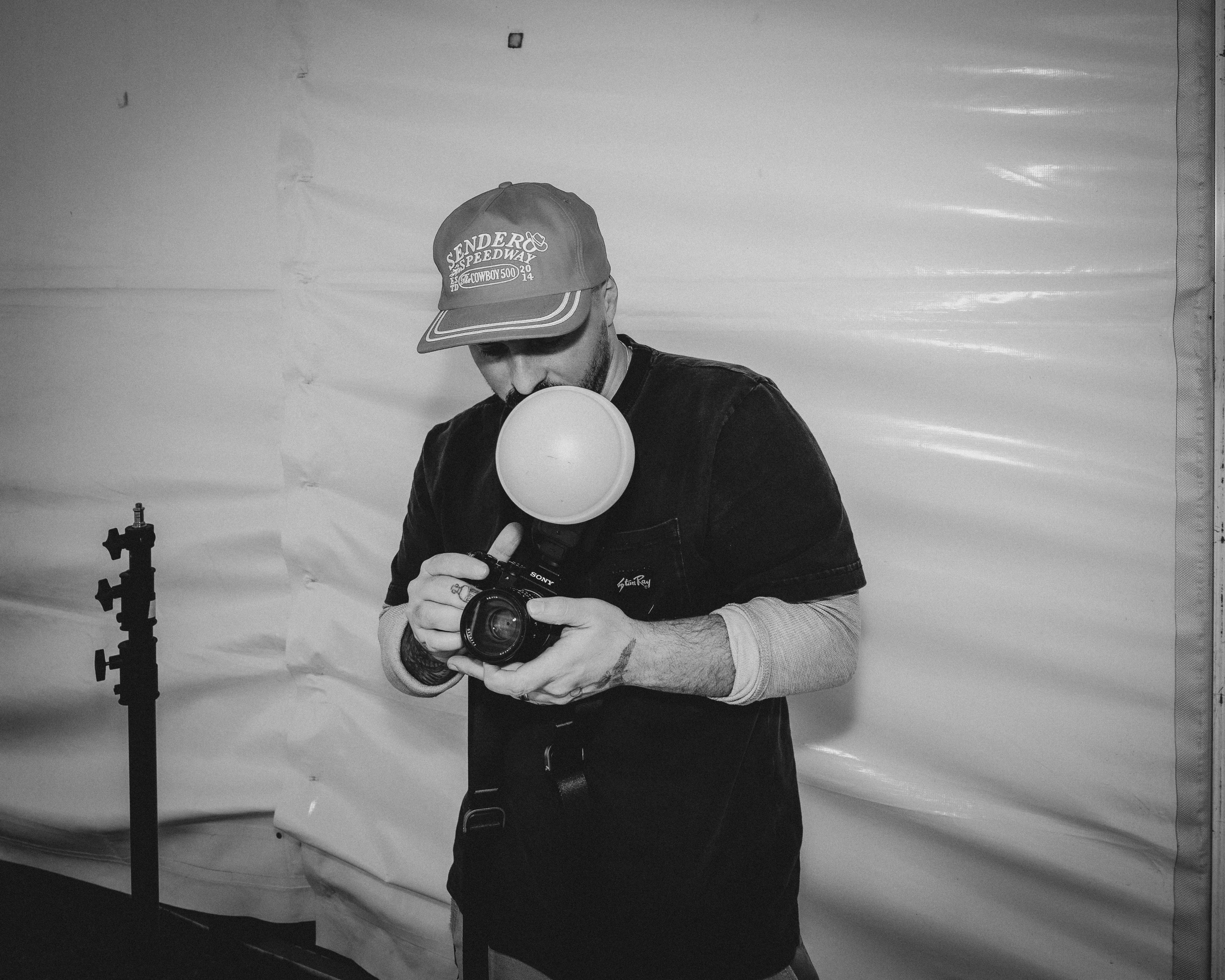 Black-and-white portrait of Jeremy Aaron Davis holding a camera